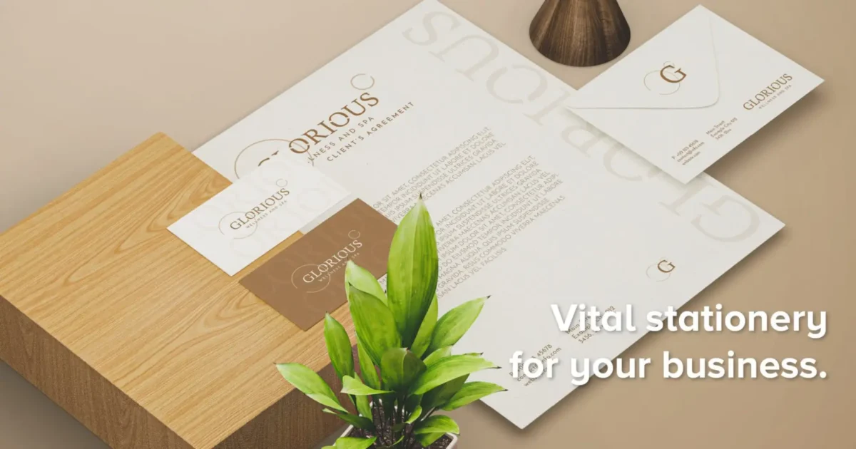 Branded stationery mockup with business cards, letterhead and envelope for "Glorious" on a wooden table with a plant