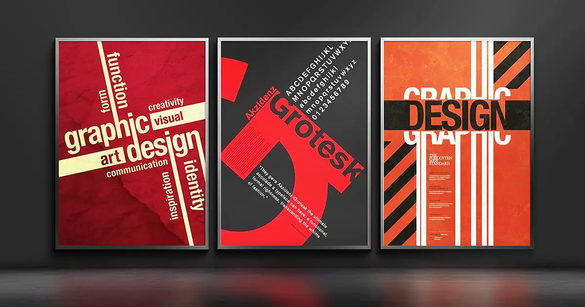 Three framed graphic design posters in red, dark grey and orange displayed on a dark wall